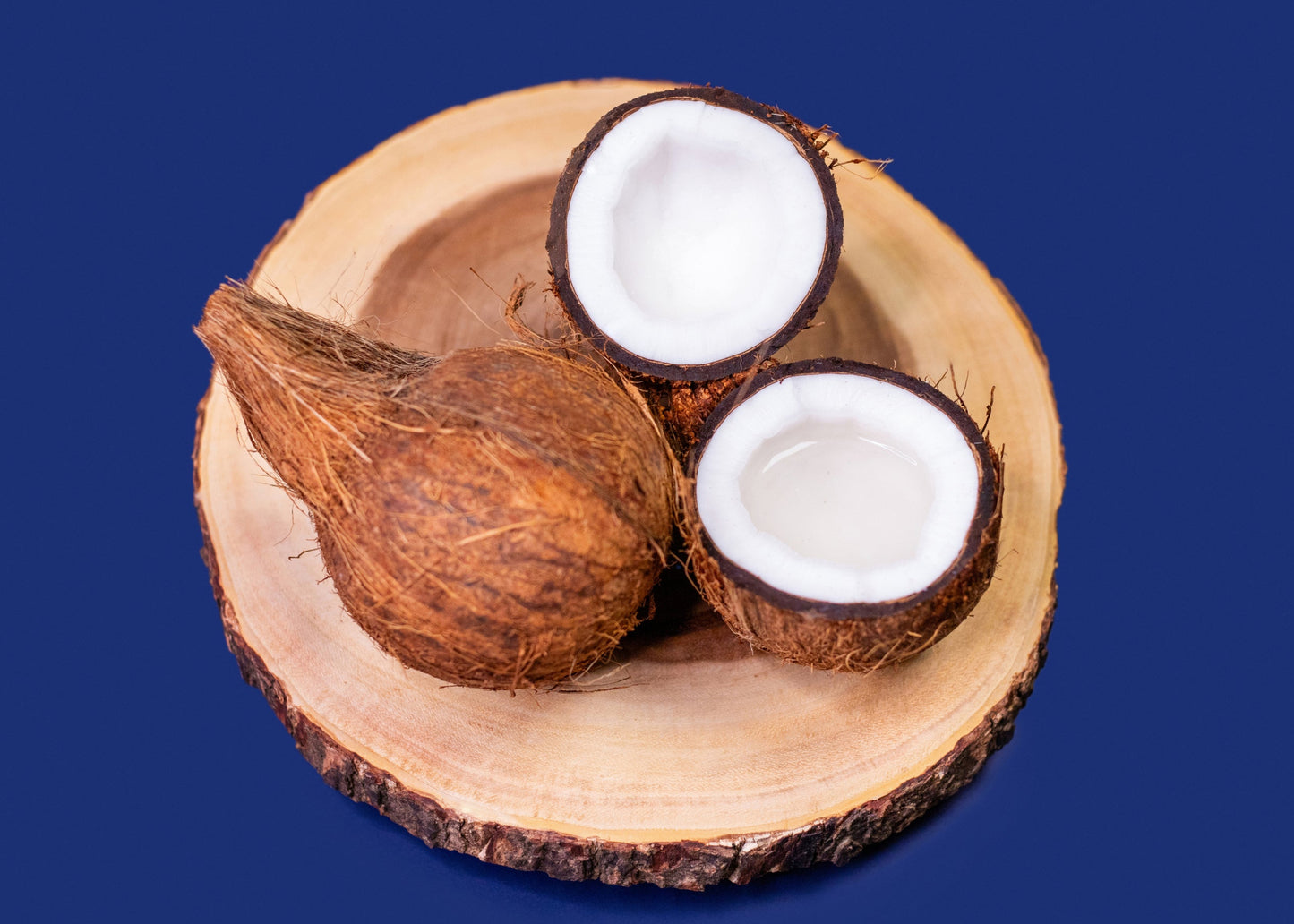 Coconuts on a wooden plate with a blue background
