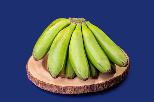 Matoke bananas on a wooden board with a blue background