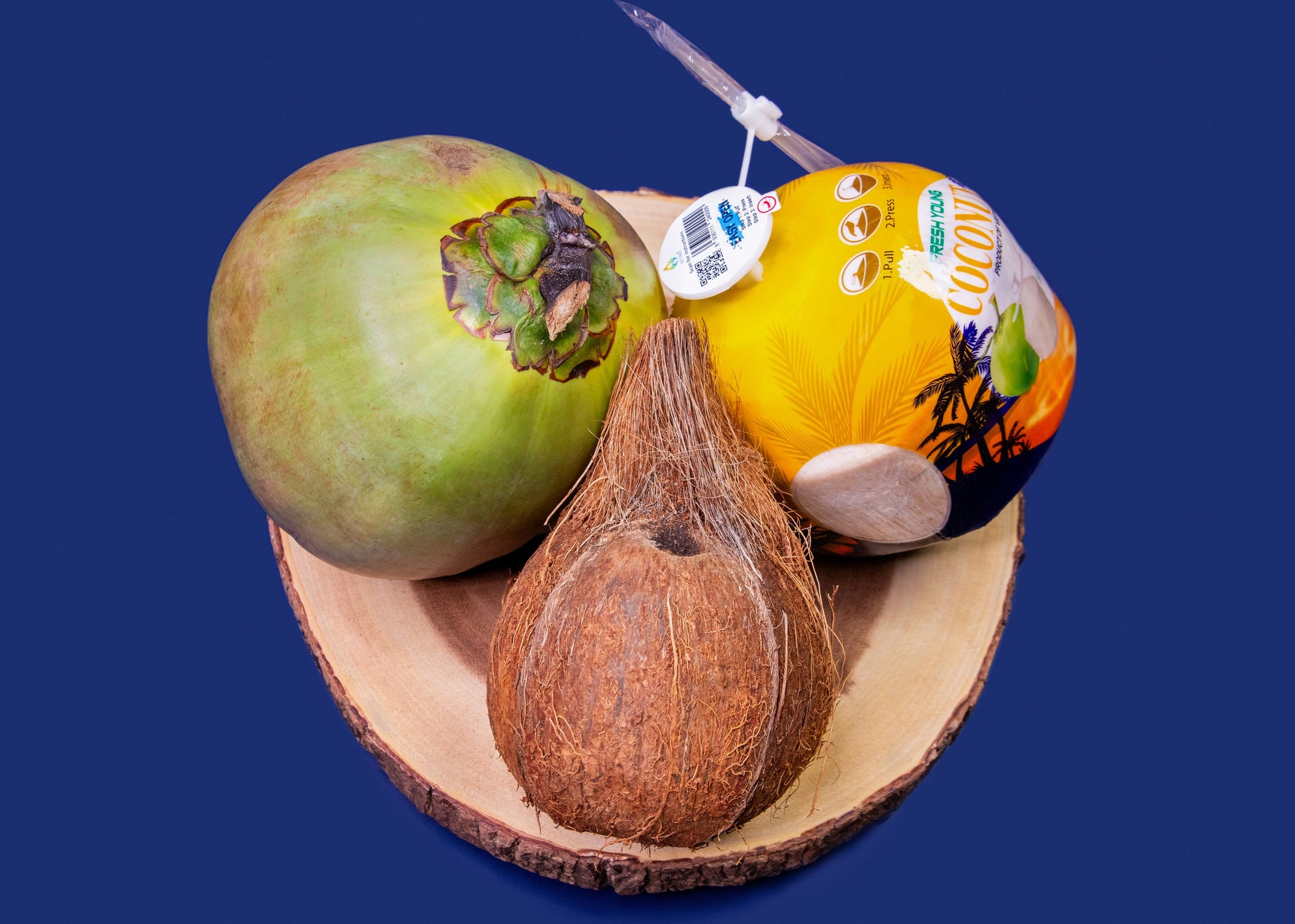 Three Coconuts on a wooden surface with a blue background