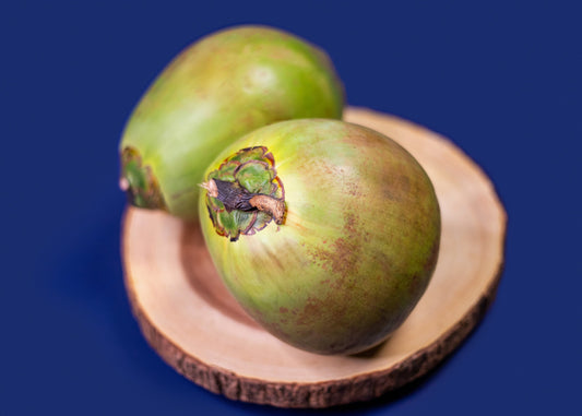 Two Young Jelly Coconuts on a wooden slice against a blue background